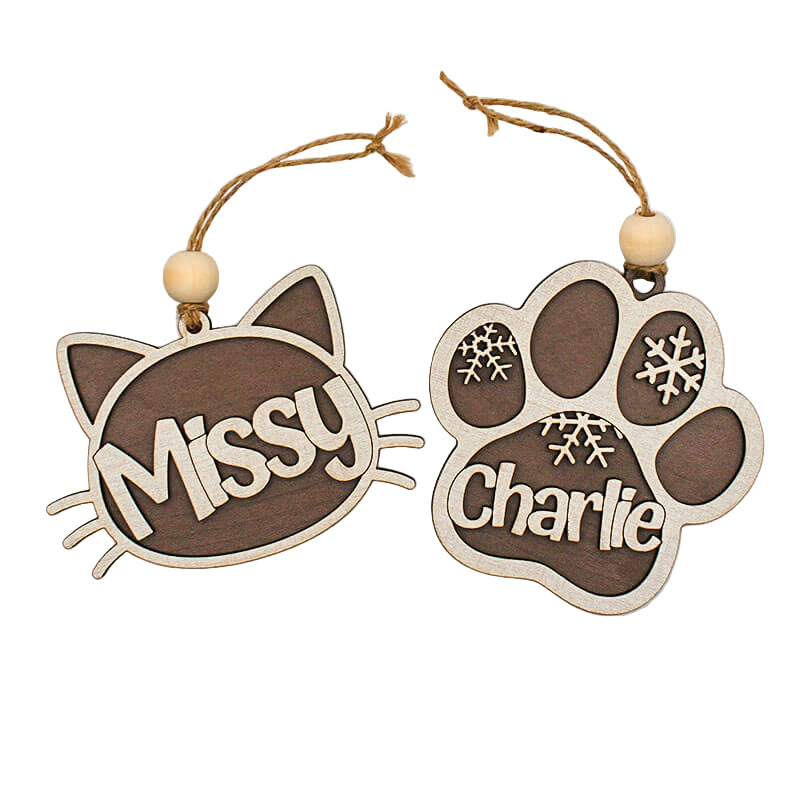 Two wooden ornaments shaped like a cat face and a paw print with names 'Missy' and 'Charlie'.