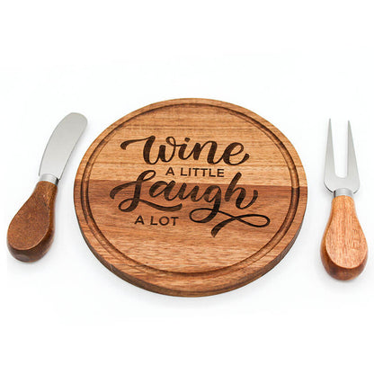 Wooden cutting board with 'Wine a little, Laugh a lot' text, knife, and fork on a white background